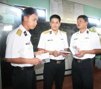Thiếu tá Nguyễn Văn Tạo (bìa trái) trao đổi chuyên môn nghiệp vụ với đồng nghiệp.