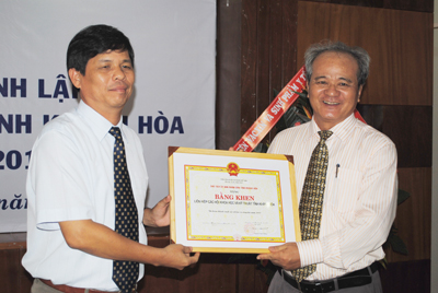 Ông Nguyễn Tấn Tuân (bìa trái) trao bằng khen của UBND tỉnh cho Liên hiệp hội.