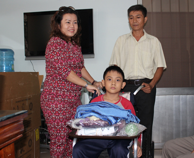 Đại diện Công ty Rồng Đỏ Châu Á trao xe lăn cho em  Nguyễn Nhật Tùng (xã Diên Thạnh, huyện Diên Khánh).