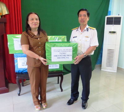 Đại tá Nguyễn Viết Thuân (bên phải) nhận quà cho trẻ em ở Trường Sa.