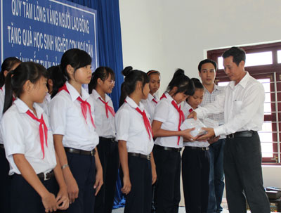 Ông Lê Xuân Hải - Phó Chủ tịch Liên đoàn Lao động tỉnh trao quà cho học sinh.