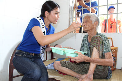 Trương Thị May đút cơm cho 1 cụ già.