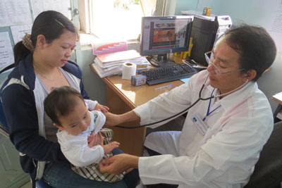 Cán bộ Trạm Y tế phường Vĩnh Nguyên tiêm vắc xin Quivaxem cho trẻ.