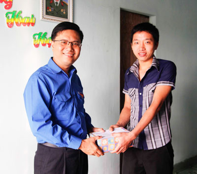 Anh Nguyễn Trung Dũng - Bí thư Thành đoàn (bên trái) trao quà động viên thanh niên lên đường làm nghĩa vụ quân sự.