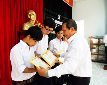 Lãnh đạo huyện trao giấy khen cho học sinh giỏi.