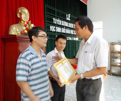 Ông Nguyễn Văn Ghi trao giấy khen của Hội Khuyến học huyện cho học sinh đỗ đại học đạt điểm cao năm học 2013 - 2014.