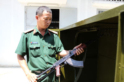 Thượng úy Nguyễn Minh Đức đang kiểm tra vũ khí quân dụng tại một đơn vị quân đội.