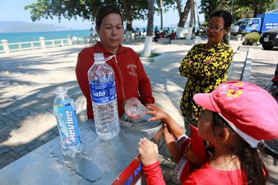 Người dân sử dụng máy cung cấp nước sạch miễn phí tại công viên bờ biển đường Trần Phú.