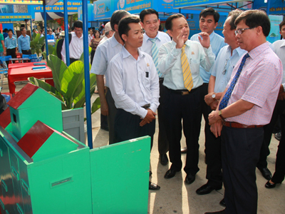 Ông Nguyễn Tấn Tuân (bìa phải) nghe giới thiệu về máy ấp trứng chim yến