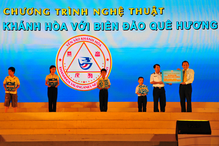Ông Lê Hữu Hoàng (bên phải) trao tượng trưng 150 triệu đồng tiền học bổng (50 suất) cho con các cán bộ, chiến sĩ đang công tác tại Trường Sa