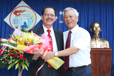 Ông Nguyễn Chiến Thắng tặng hoa chúc mừng cho đại diện lãnh đạo Trường THPT Lý Tự Trọng.