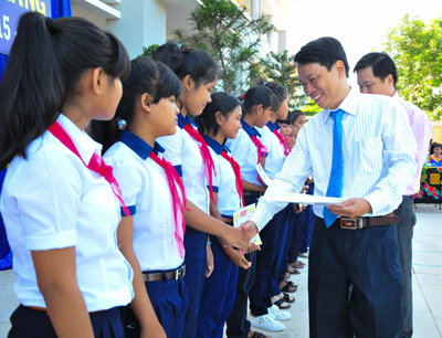 2.	Đại diện Báo Khánh Hòa và Công ty TNHH Long Sinh trao học bổng cho các học sinh