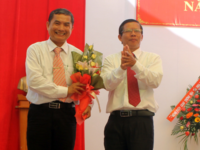 Ông Trần Ngọc Thanh tặng hoa chúc mừng cho đại diện lãnh đạo nhà trường.