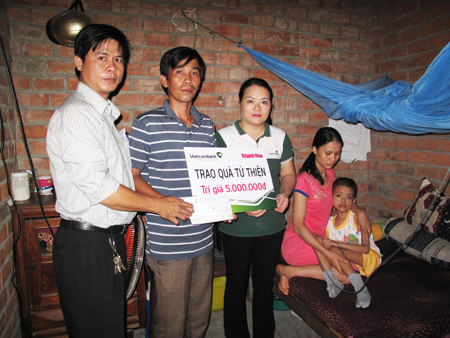Đại diện Báo Khánh Hòa và Vietcombank Nha Trang trao tiền cho gia đình cháu An