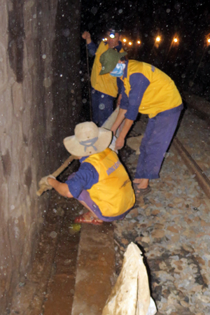 Công nhân duy tu đội Đường sắt Đèo Cả đang khơi thông rãnh nước trong hầm Đá Đá Đen