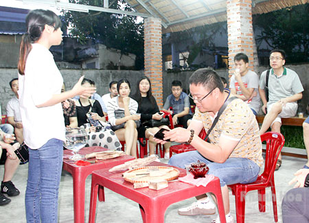 Khách du lịch Trung Quốc xem giới thiệu về trầm hương tại một cơ sở bán trầm hương ở Nha Trang