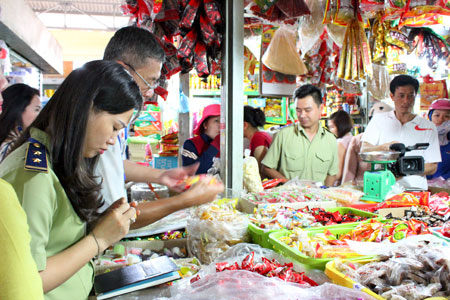 Cán bộ Đội Quản lý thị trường số 1 kiểm tra mặt hàng bánh kẹo tại chợ Vĩnh Hải.