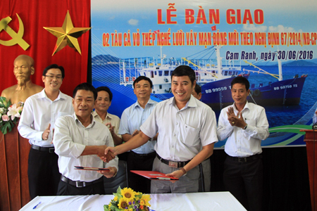 Đại diện Công ty TNHH một thành viên Đóng tàu Cam Ranh (phải) bàn giao thông số kỹ thuật tàu vỏ thép cho ngư dân
