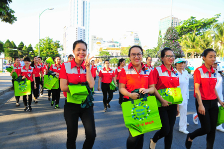 Các nhân viên Lotte Mart mang theo túi  thân thiện môi trường để phát cho người dân.
