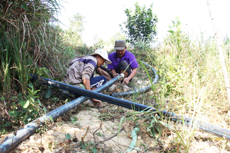 Người dân xã Sơn Trung lắp ống, đưa nước lên đồi tưới cây