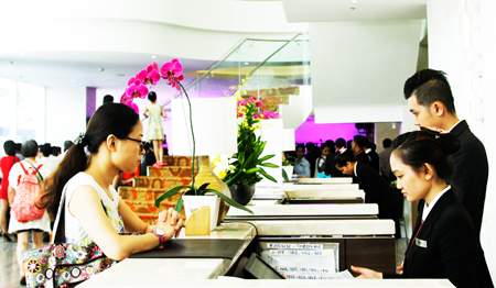 Nhân viên lễ tân khách sạn Liberty Central Nha Trang đang làm thủ tục nhận phòng cho khách