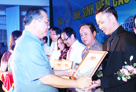 Huynh Van Ti offering certificates of merit to individuals.