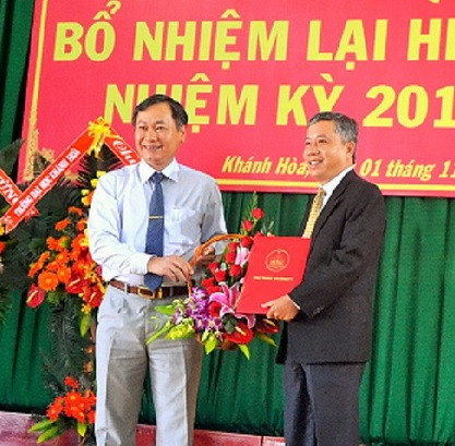 Ông Nguyễn Đắc Tài (bìa trái) trao quyết định bổ nhiệm lại hiệu trưởng cho PGS.TS Trang Sĩ Trung. 