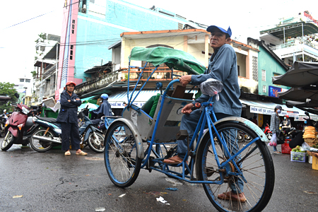 Pedicab driver waiting for customer at Xom Moi Market.