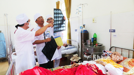 Bác sĩ Quang (đứng giữa) trao đổi với đồng nghiệp về bệnh án của bệnh nhân