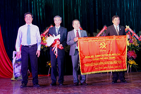 Ông Lê Thanh Quang (bìa trái) trao bức trướng cho lãnh đạo TP. Nha Trang.