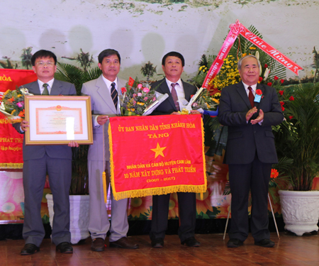 Ông Đào Công Thiên trao bằng khen và cờ thi đua cho cán bộ, nhân dân huyện.
