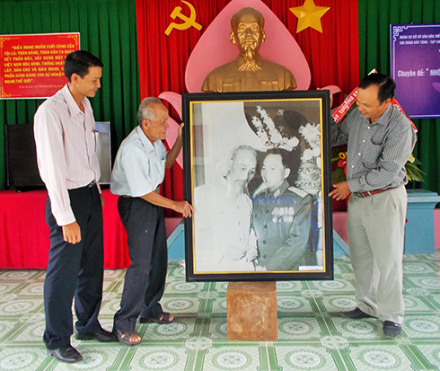 Đại diện Đảng ủy, UBND xã Phước Đồng tặng bức tranh cho khu lưu niệm