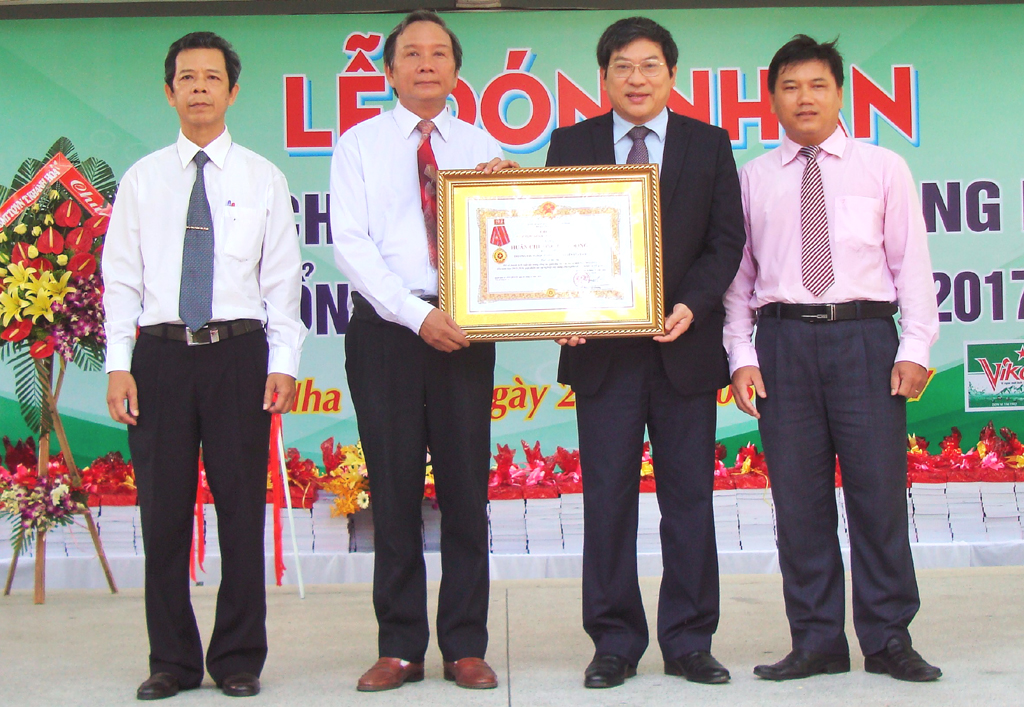 Ông Nguyễn Duy Bắc (thứ 2 từ phải qua) trao Huân chương lao động hạng Nhì cho nhà trường. 