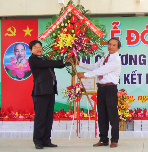 Ông Nguyễn Duy Bắc tặng hoa chúc mừng của UBND tỉnh cho nhà trường. 