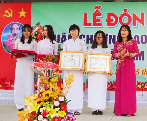 Bà Hoàng Thị Lý trao giấy khen cho 2 em đạt giải học sinh giỏi quốc gia. 