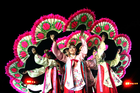 Artists from South Korea performing their traditional dance with fans.