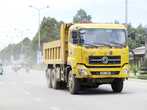 Xe tải chở đất cuốn theo bụi trên đường 23-10, đoạn qua xã Vĩnh Trung. 
