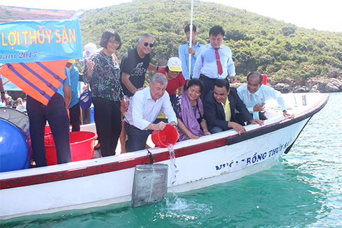 Các vị khách quốc tế cùng tham gia thả cá tái tạo nguồn lợi thủy sản. 