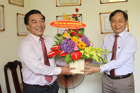 Ông Nguyễn Đắc Tài (bên phải) tặng hoa chúc mừng lãnh đạo Hội Nhà báo tỉnh Khánh Hòa.