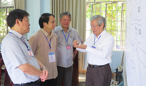 Thứ trưởng Phạm Mạnh Hùng (thứ 2 từ trái sang) trao đổi với lãnh đạo Sở Giáo dục - Đào tạo để sơ đồ phòng thi tại điểm thi trường THCS Thái Nguyên