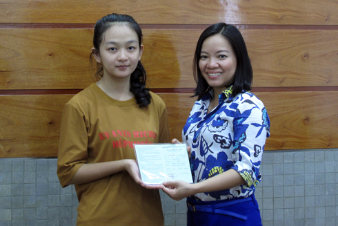 Bà Thái Thị Lệ Hằng - Phó Tổng Biên tập Báo Khánh Hòa trao sổ tiết kiệm cho cháu Minh Thư