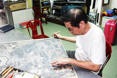 Họa sĩ Nguyễn Quang Tuyến đang làm bản khắc bức tranh Chợ tình