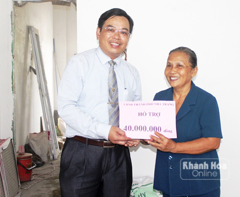 Đại diện lãnh đạo TP. Nha Trang trao tiền hỗ trợ xây nhà tình nghĩa cho bà Võ Thị Tặng