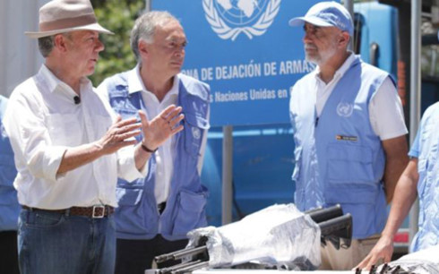 Tổng thống Colombia Juan Manuel Santos (trái) và các nhân viên Liên Hợp Quốc chứng kiến container vũ khí cuối cùng rời đi. (Ảnh: BBC)