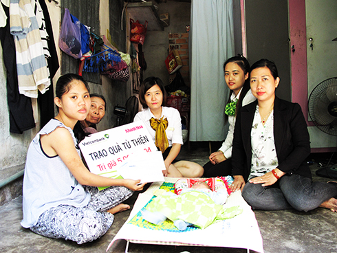 Đại diện Báo Khánh Hòa và Vietcombank Nha Trang trao tiền ủng hộ cho gia đình bé Kim Sang