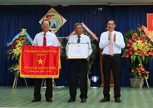 Ông Lê Đức Vinh trao cờ thi đua xuất sắc cho Trường THPT Lý Tự Trọng. 