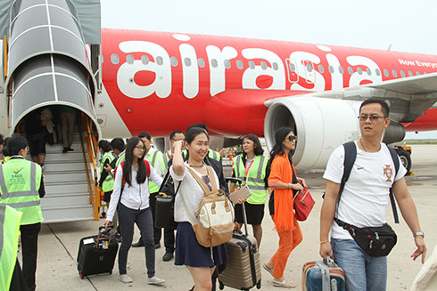 Những hành khách đầu tiên của chuyến bay từ Kuala Lumpur xuống Sân bay quốc tế Cam Ranh.