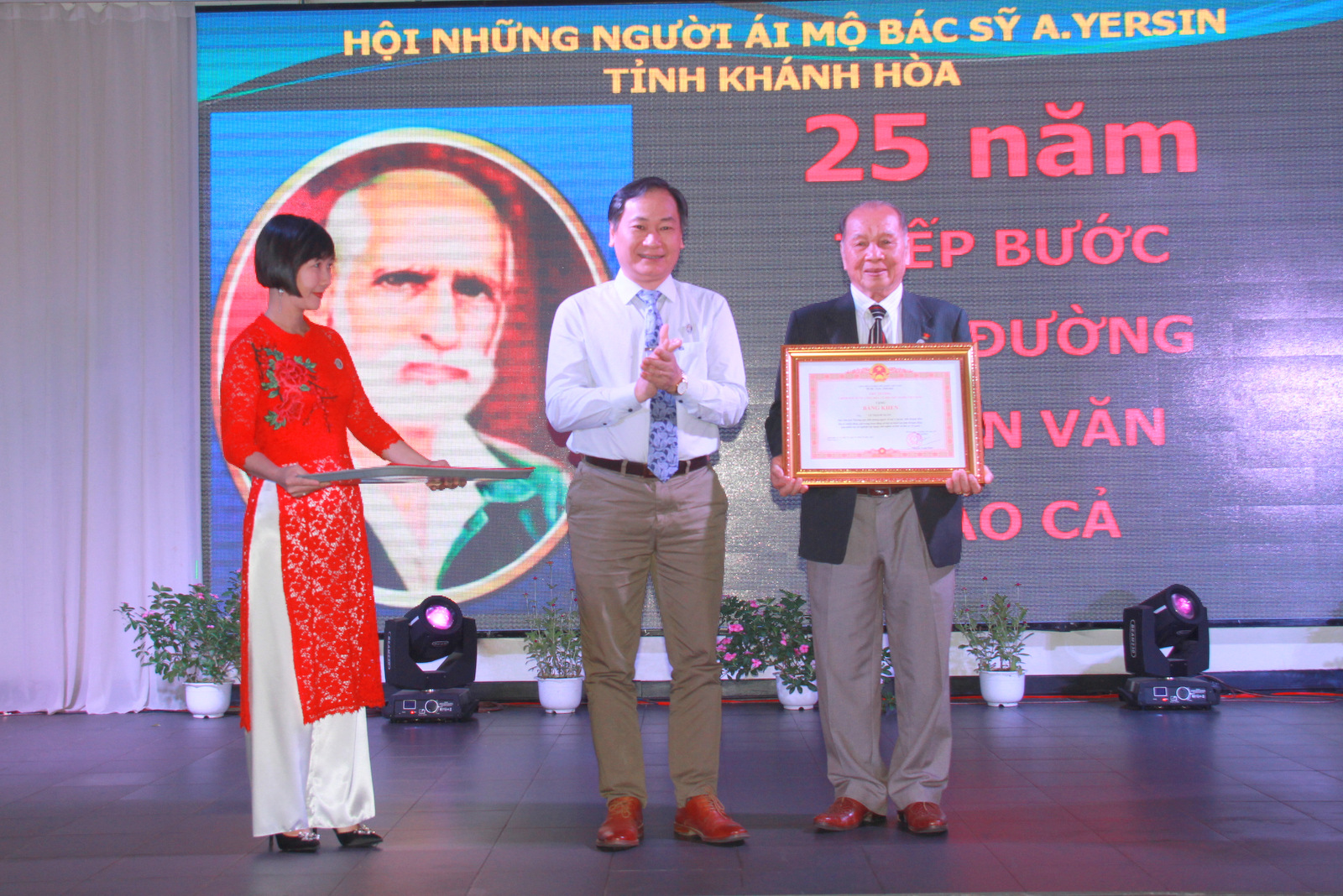 Nguyen Dac Tai giving Prime Minister’s certificate of merit to Le Thanh Xuan.