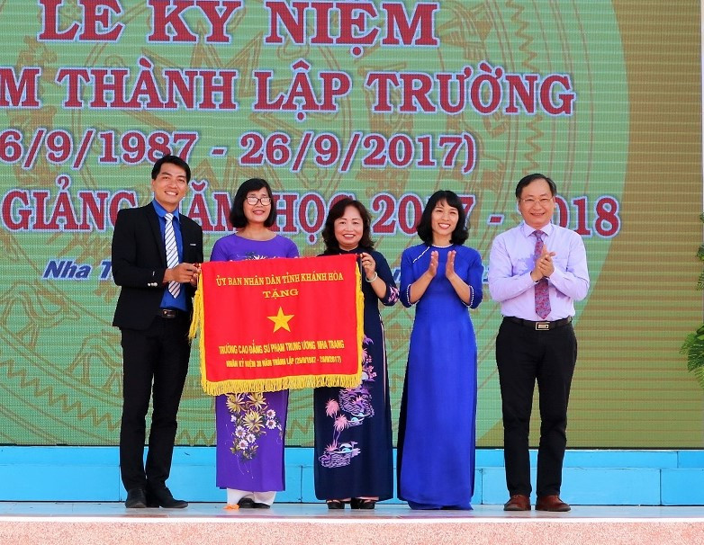 Ông Nguyễn Đắc Tài trao cờ thi đua của UBND tỉnh cho nhà trường. 
