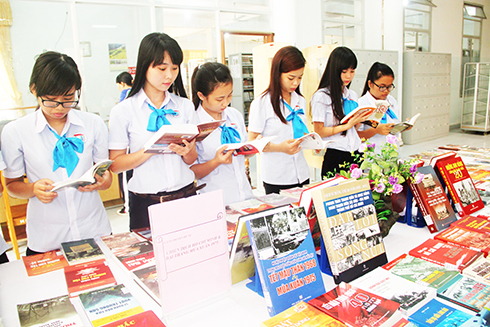 Độc giả trẻ xem sách về lịch sử được trưng bày tại Thư viện tỉnh